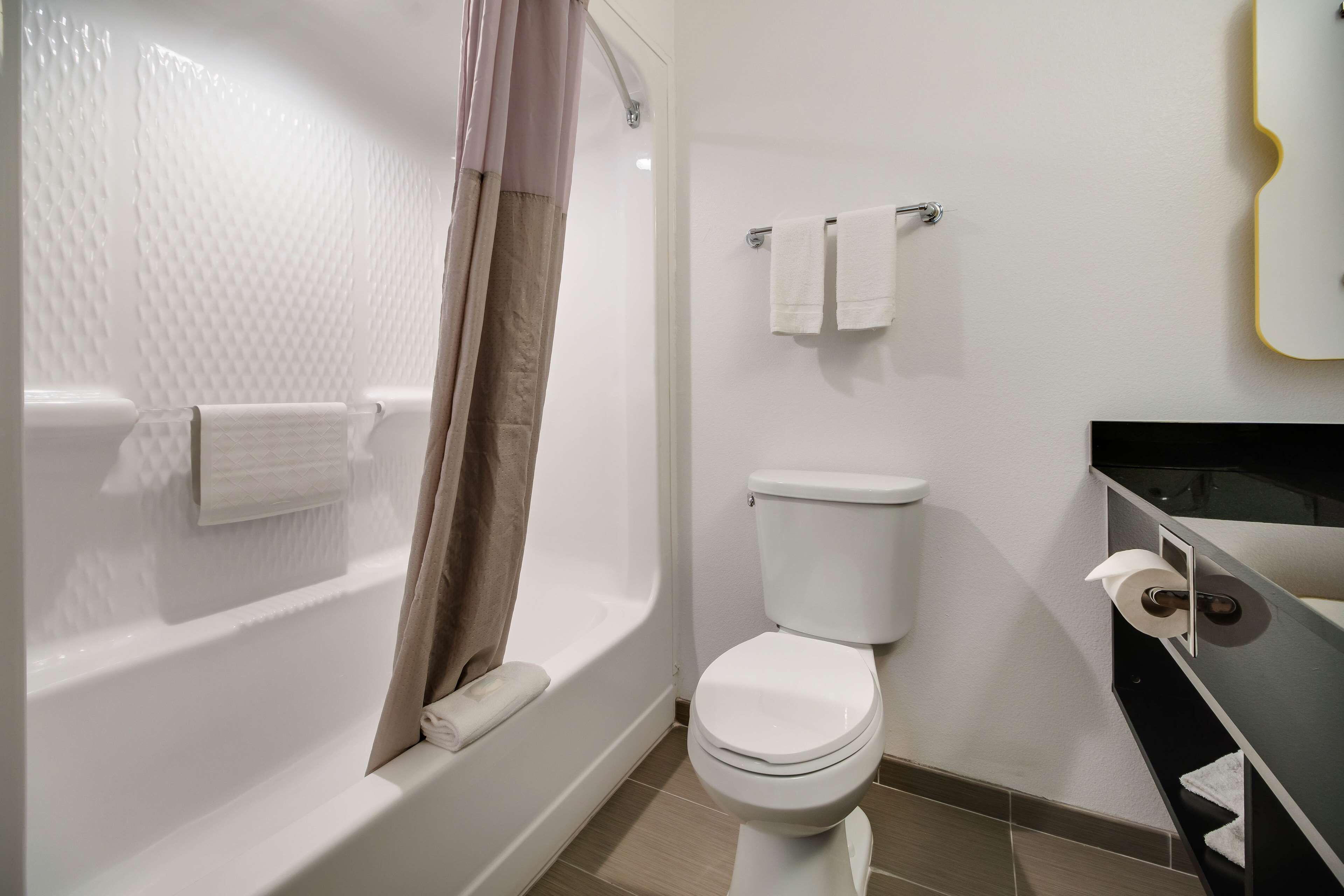 A bathroom with a bathtub, toilet, and a towel rack.