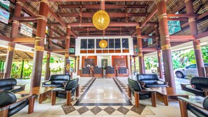 A reception area with a check-in desk, black leather seating, and a tiled floor. - Tanoa Tusitala Hotel (Apia)