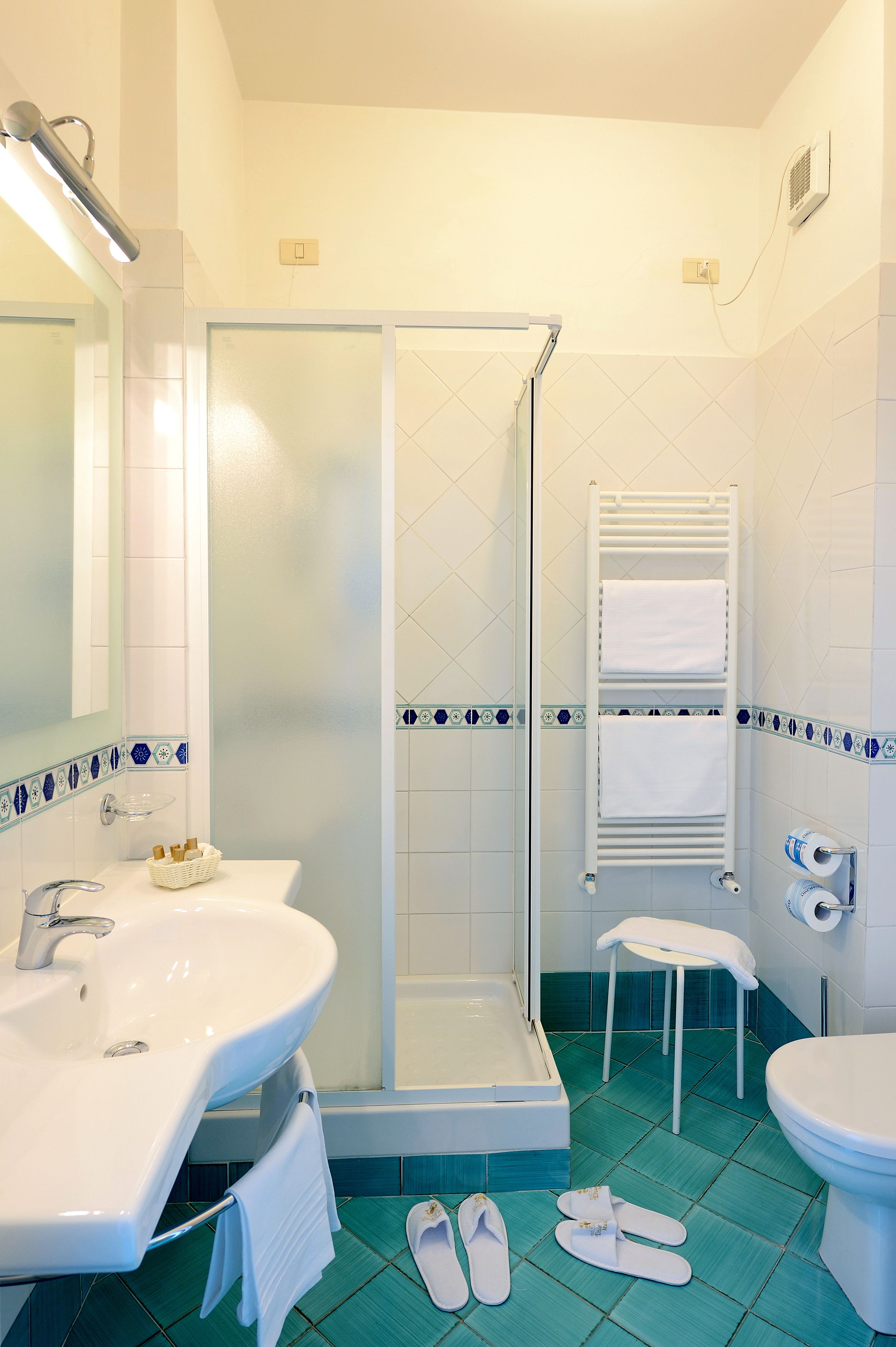Un baño con lavamanos, inodoro y ducha.