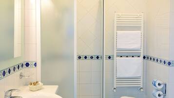 A bathroom with a sink, toilet, and shower.