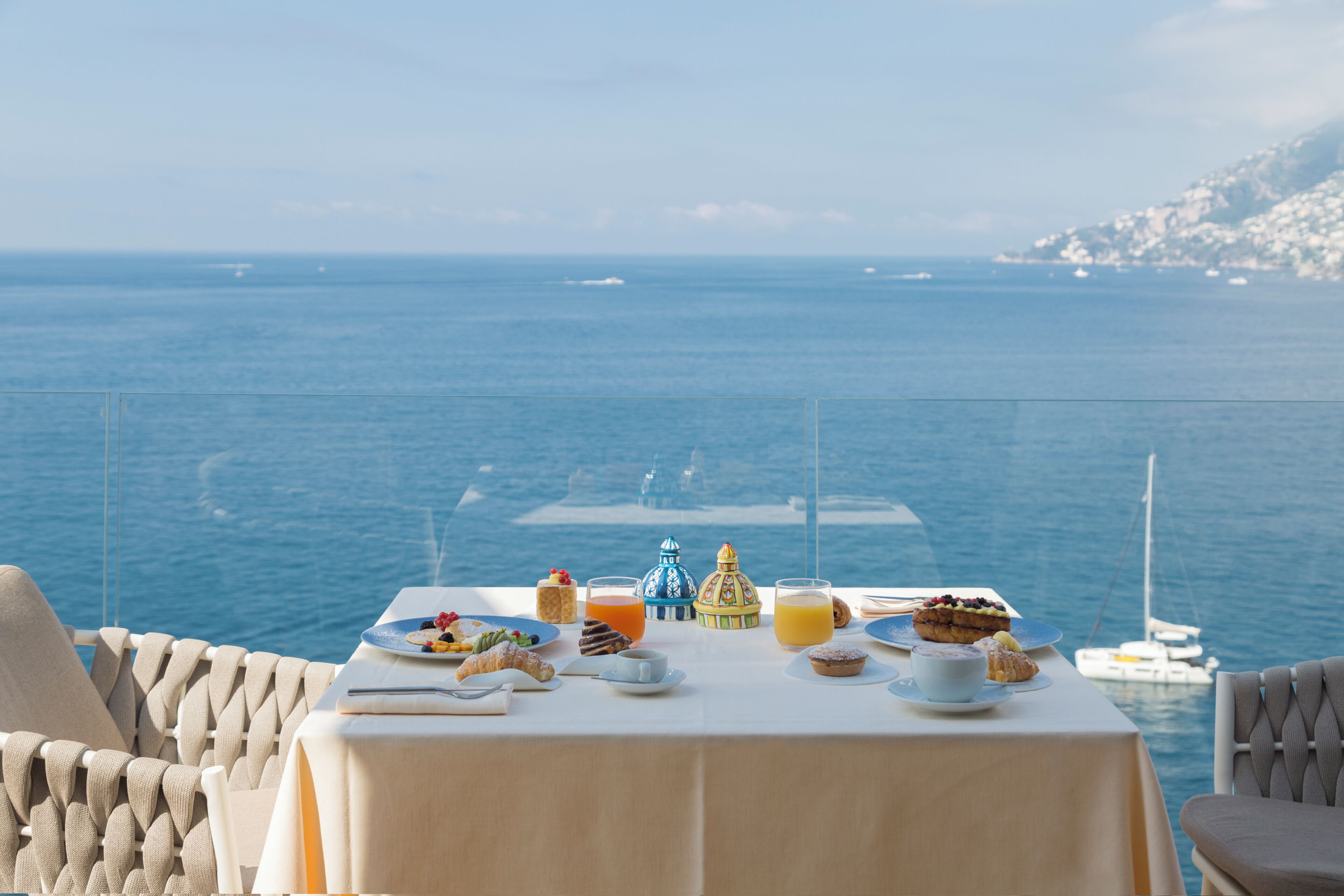 A table set with breakfast items overlooking the sea.