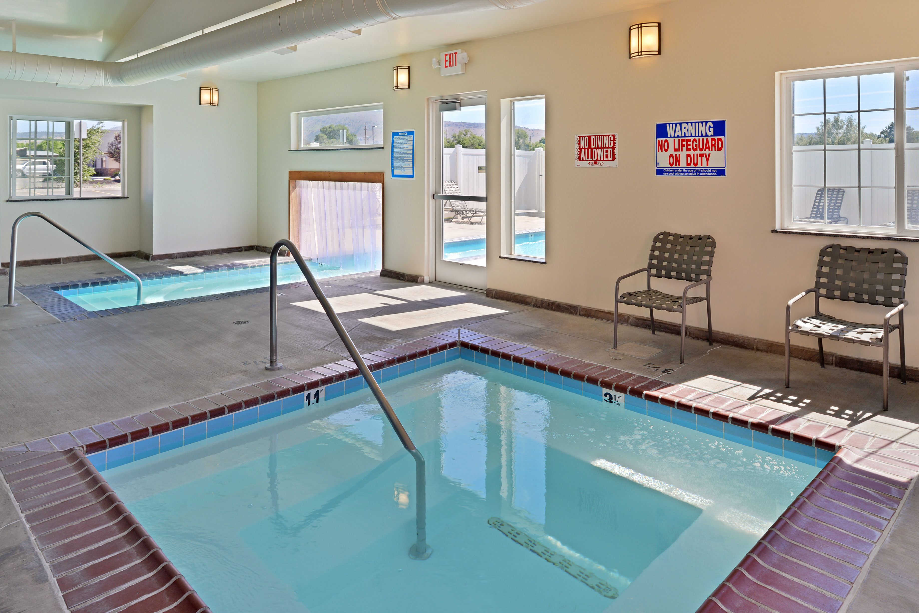 A swimming pool with a lifeguard chair and a warning sign.