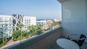 A balcony with a white table and chair, overlooking a cityscape with modern buildings and palm trees. - Hotel THB Niagara - Adults Only (Palma de Mallorca)