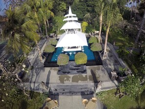 Un temple traditionnel doté d’un sanctuaire central, entouré d’un jardin agrémenté de palmiers et d’arbustes soigneusement taillés.