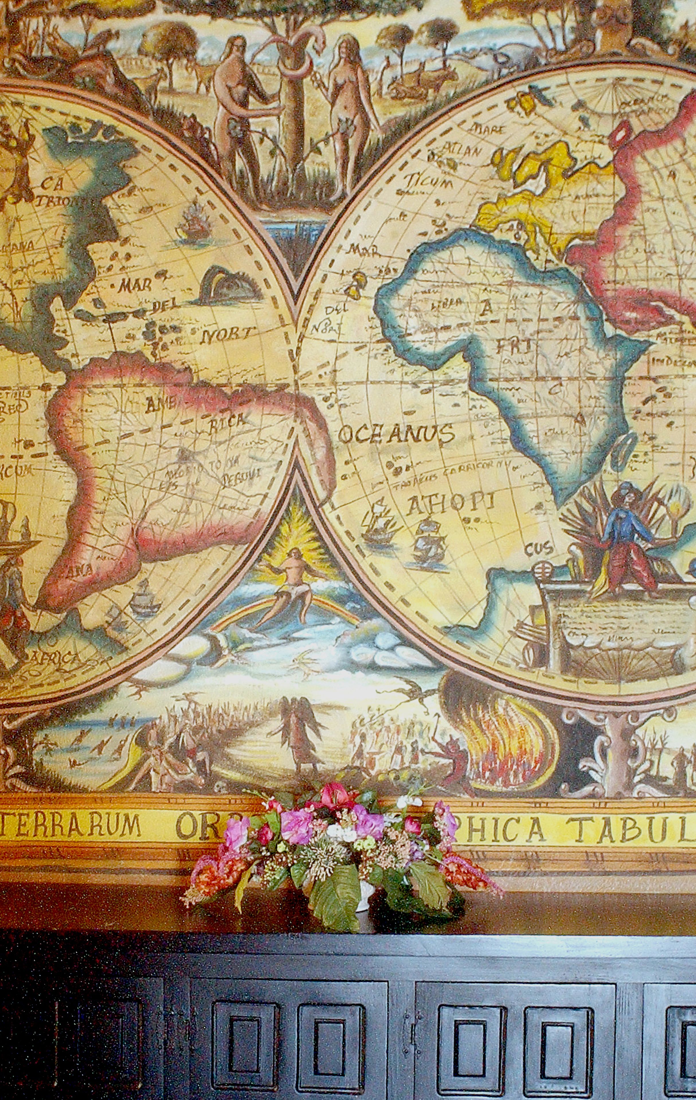 A detailed map with a decorative border, featuring a central emblem and a floral arrangement below.