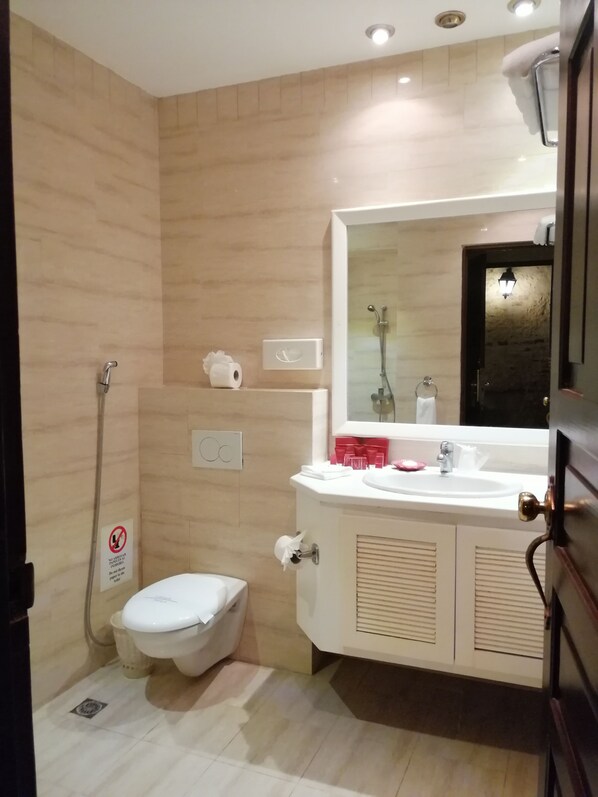 A compact bathroom with a toilet, sink, and shower.