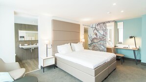 A modern hotel room with a large bed, a desk, a chair, and a bathroom visible through an open door. - Van der Valk Hotel Hilversum - de Witte Bergen (Eemnes)
