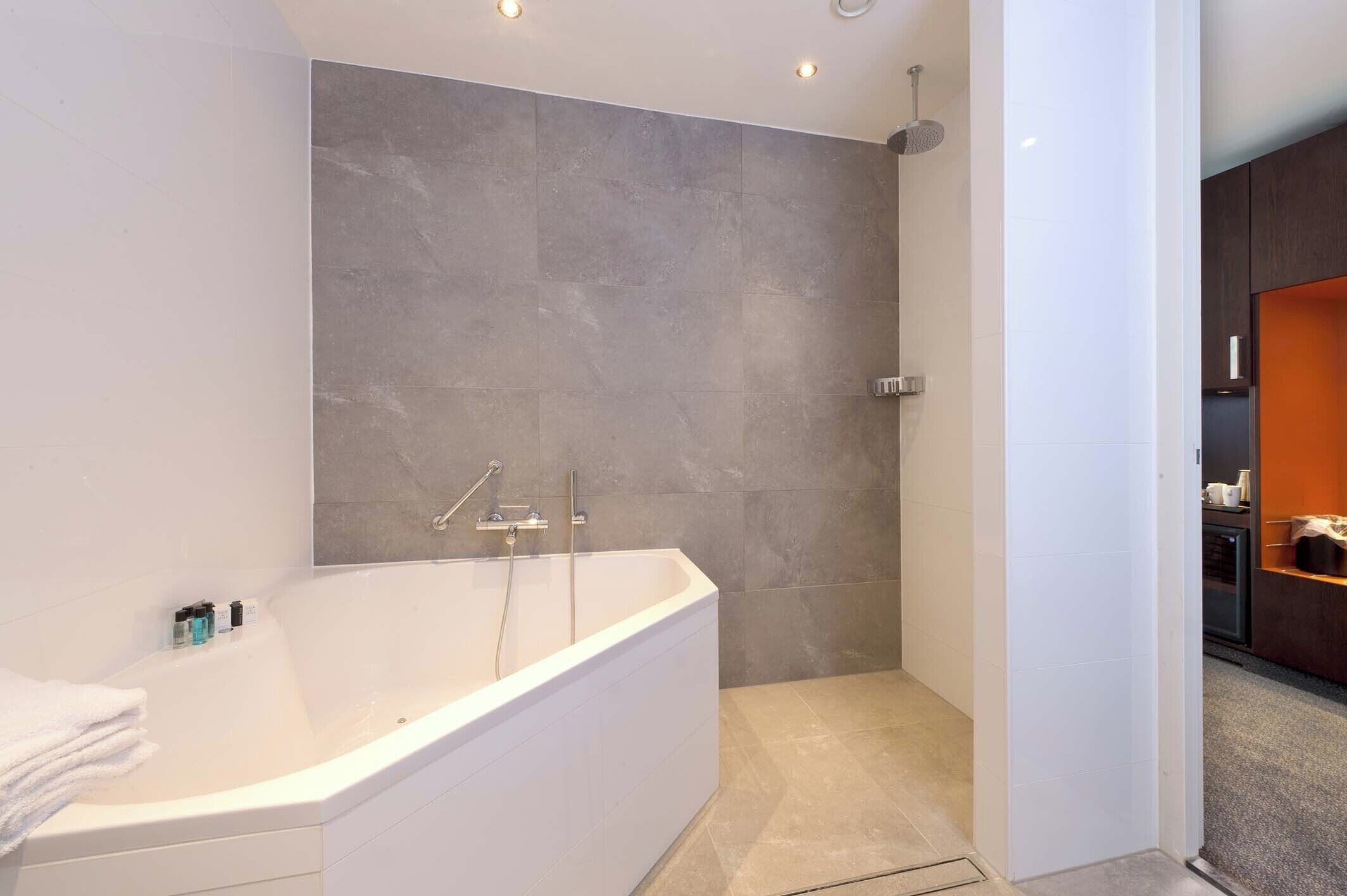 A modern bathroom with a freestanding bathtub, a shower area, and a visible sink.