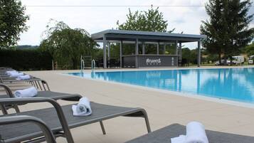 A poolside area with lounge chairs and a covered seating area at Atlantis Hotel.