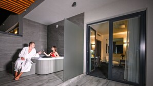 Une salle de bain moderne dotée d’une grande baignoire, d’une douche séparée et d’une entrée en verre donnant sur l’espace de vie.