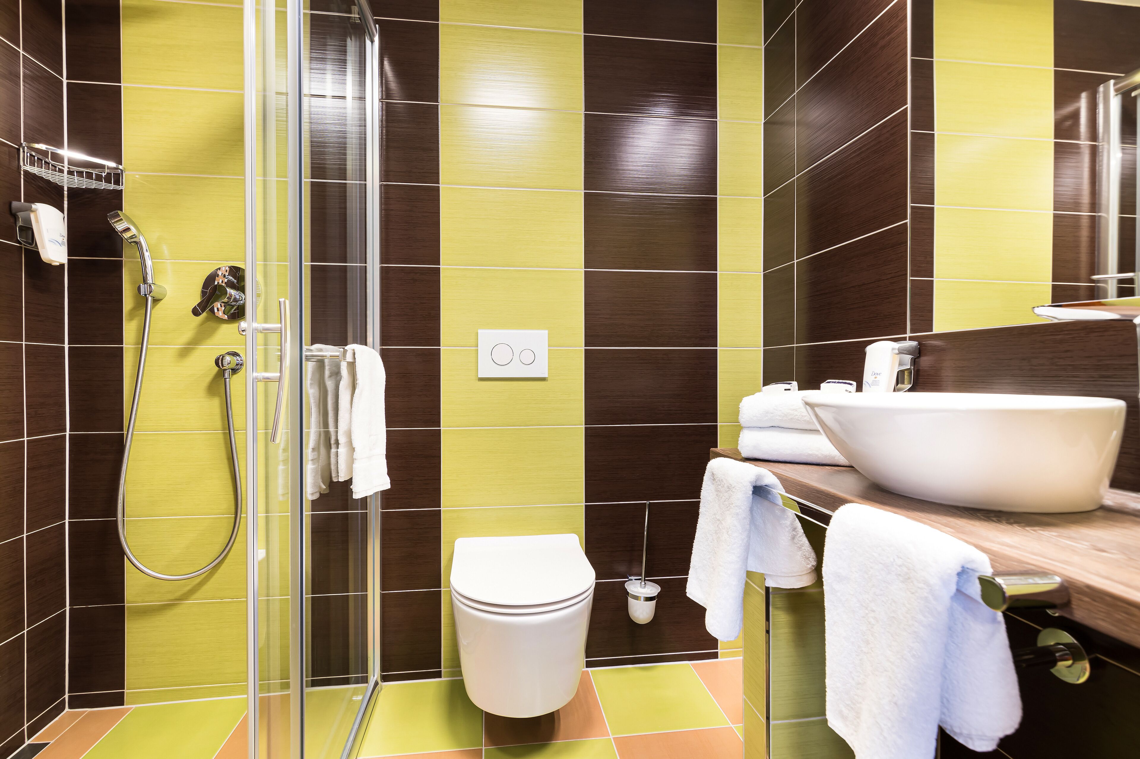 Een moderne badkamer met een glazen douchecabine, een wit toilet en een ruime wastafel met spiegel.