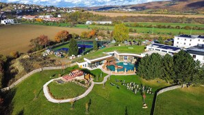 Vue aérienne d’un complexe hôtelier doté d’une piscine, d’un patio couvert et d’un salon pour les clients.