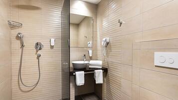 A modern bathroom with a glass-enclosed shower, a sink, and a mirror.