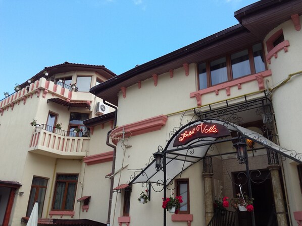A building with a balcony and a sign that reads "Hotel Volta."