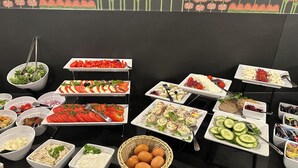 Un buffet proposant une variété de plats, notamment des salades, des fruits et des fromages.