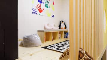 Children can play and learn in this inviting space with a play table, plush chair, and bookshelf.