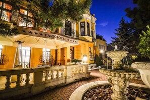 A Park Hotel with a fountain, outdoor seating, and a well-lit entrance. - Parkhotel Brno (Brno)