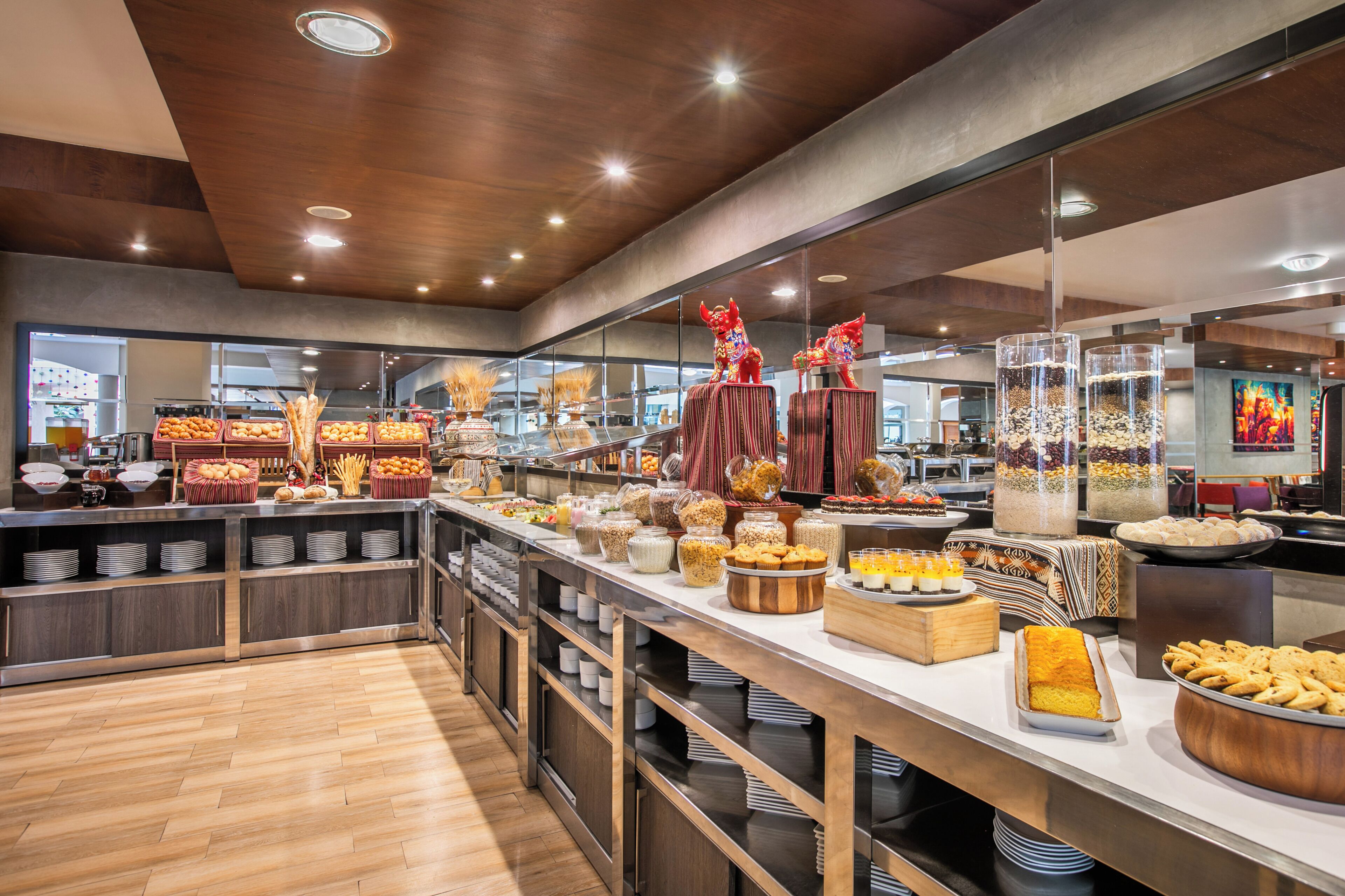 A buffet area with various food items and a decorative red lion statue.