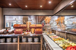 A buffet with various food items and a glass display case.