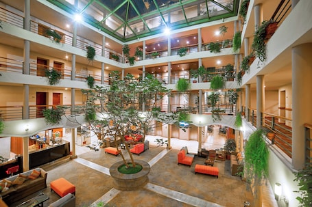 A multi-level atrium with balconies, indoor plants, and seating areas.