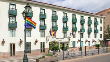 Un hotel con varios balcones, una bandera y un letrero que dice 'Hotel La Paccha'.
