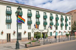 Un hotel con varios balcones, una bandera y un letrero que dice 'Hotel La Paccha'.
