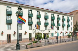 Un hotel con varios balcones, una bandera y un letrero que dice 'Hotel La Paccha'.