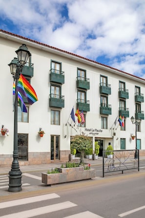 A hotel with multiple balconies, a clear sky, and flags. - Hotel Cusco La Paccha, Affiliated by Meliá (Cusco)