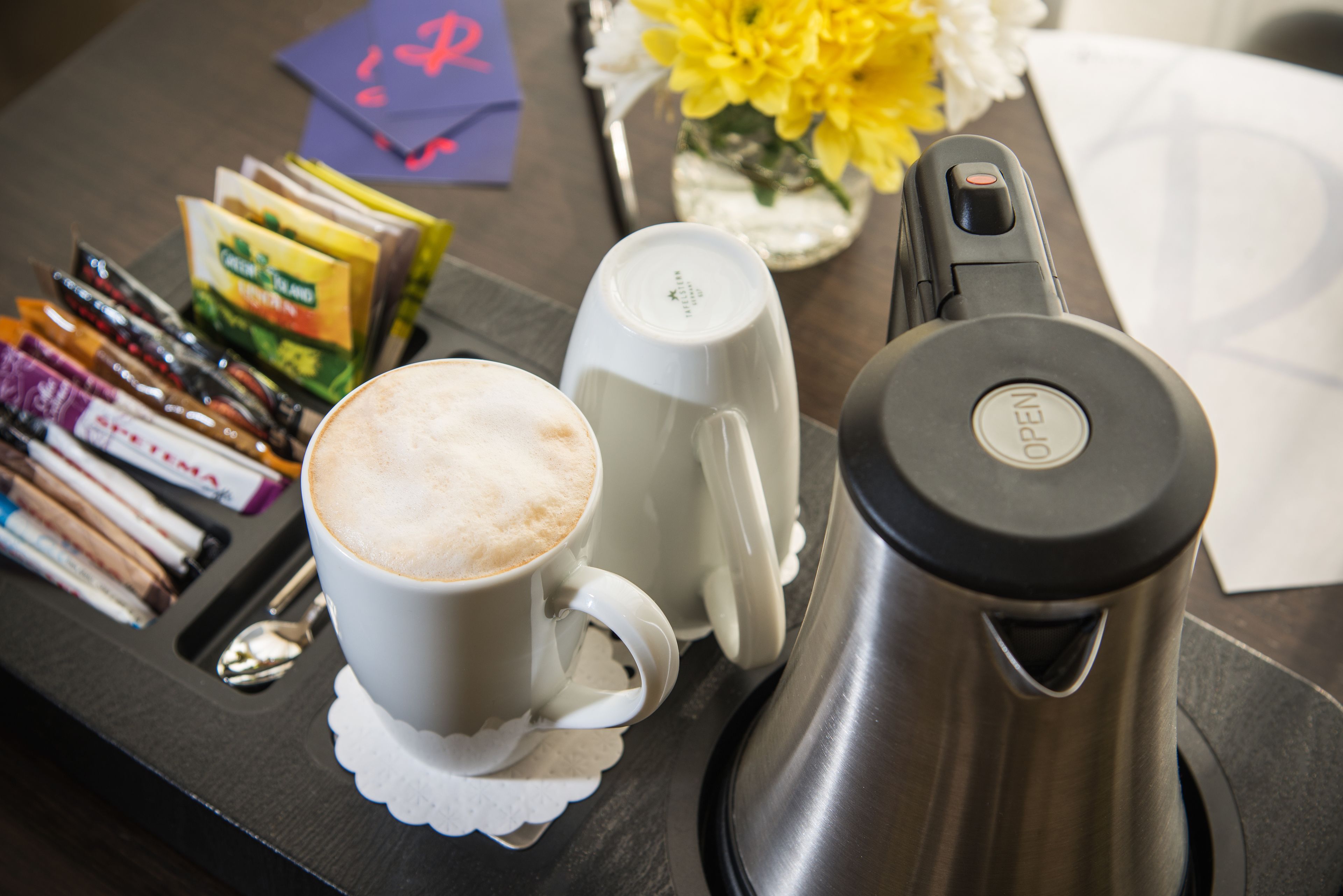 Een koffiehoek met koffiezetapparaat, bekers en koffiecups.