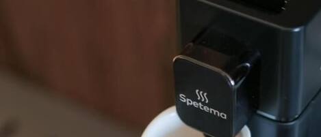 Una máquina de café vertiendo café en una taza con la etiqueta 'Spetema'.