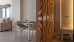 Una sala de estar moderna con comedor, un sofá y un separador de madera.