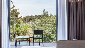 Un dormitorio con un ventanal grande, una cama, una silla y una mesa.