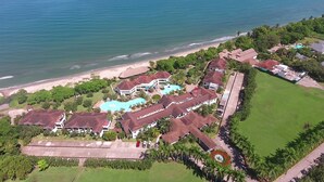 An aerial view of a resort with multiple buildings, a large swimming pool, and a beach. - Hotel Palma Real (Jutiapa)