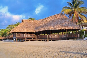 Praia particular, espreguiçadeiras, guarda-sóis, toalhas de praia 