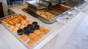 A buffet with various baked goods including muffins and pastries.