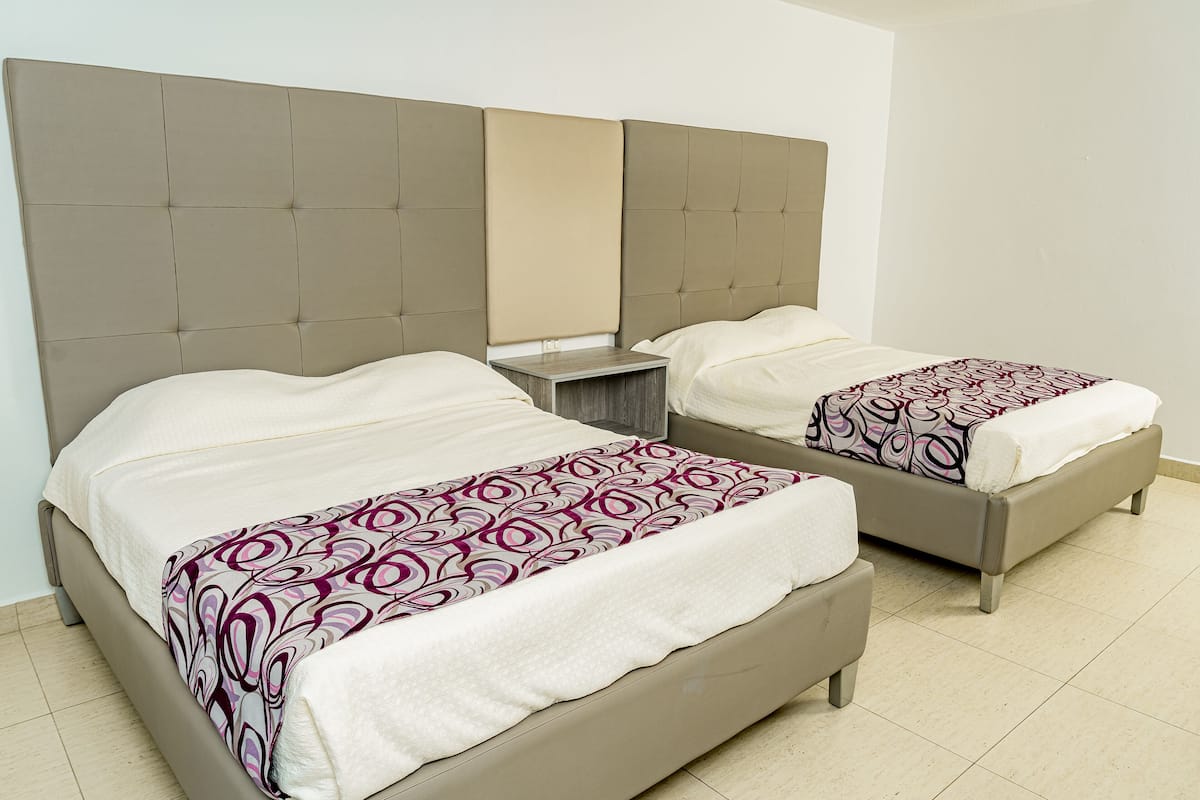 A double bed with a patterned bedspread and a headboard.