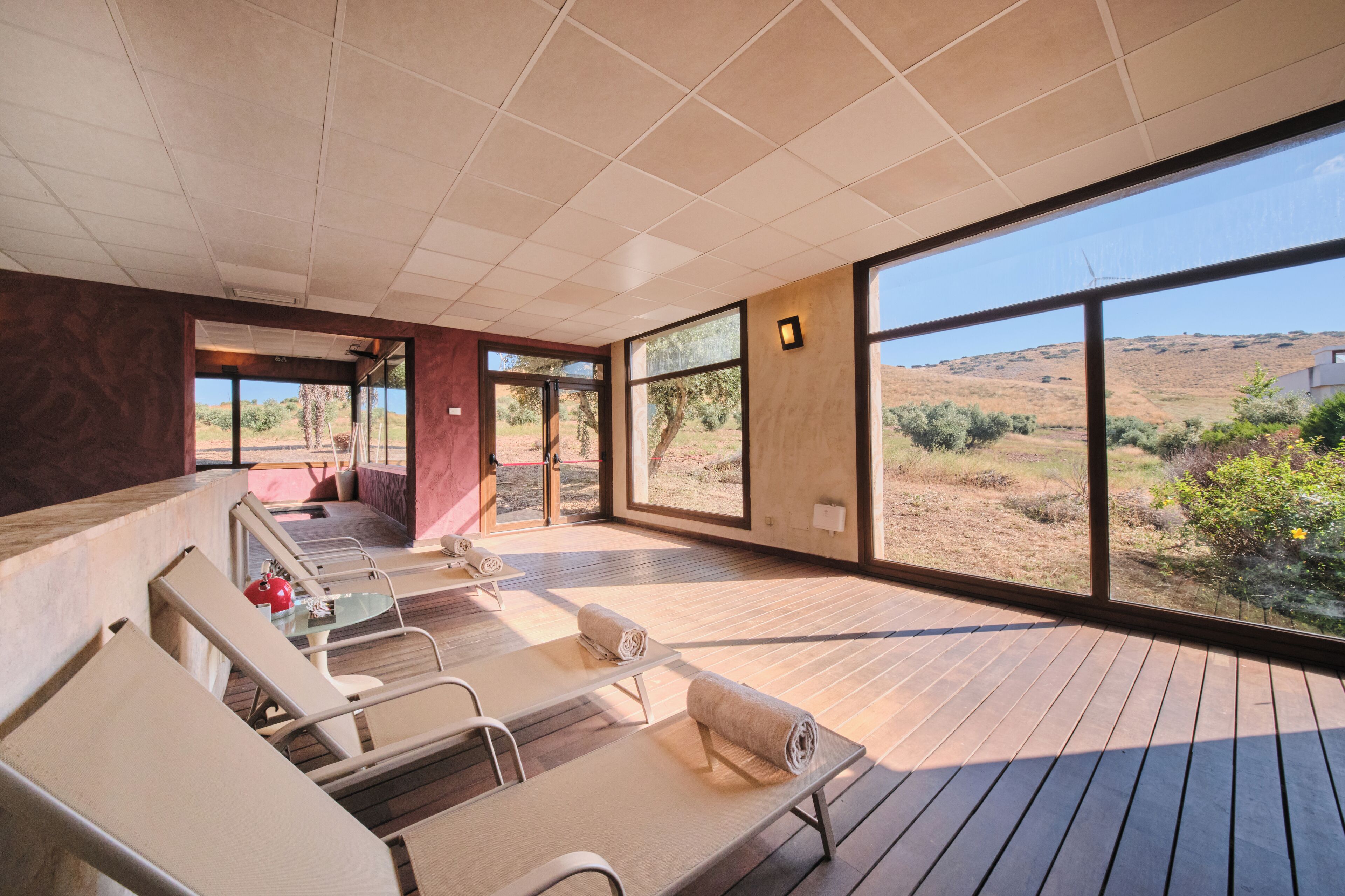 Un área de spa moderna con suelo de madera, ventanas amplias y vistas al paisaje desértico.