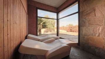 Relax in a serene spa room with a garden view, featuring three massage chairs and a calming atmosphere.
