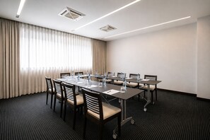 A conference room with a long table, chairs, and water bottles. - BessaHotel Boavista (Porto)