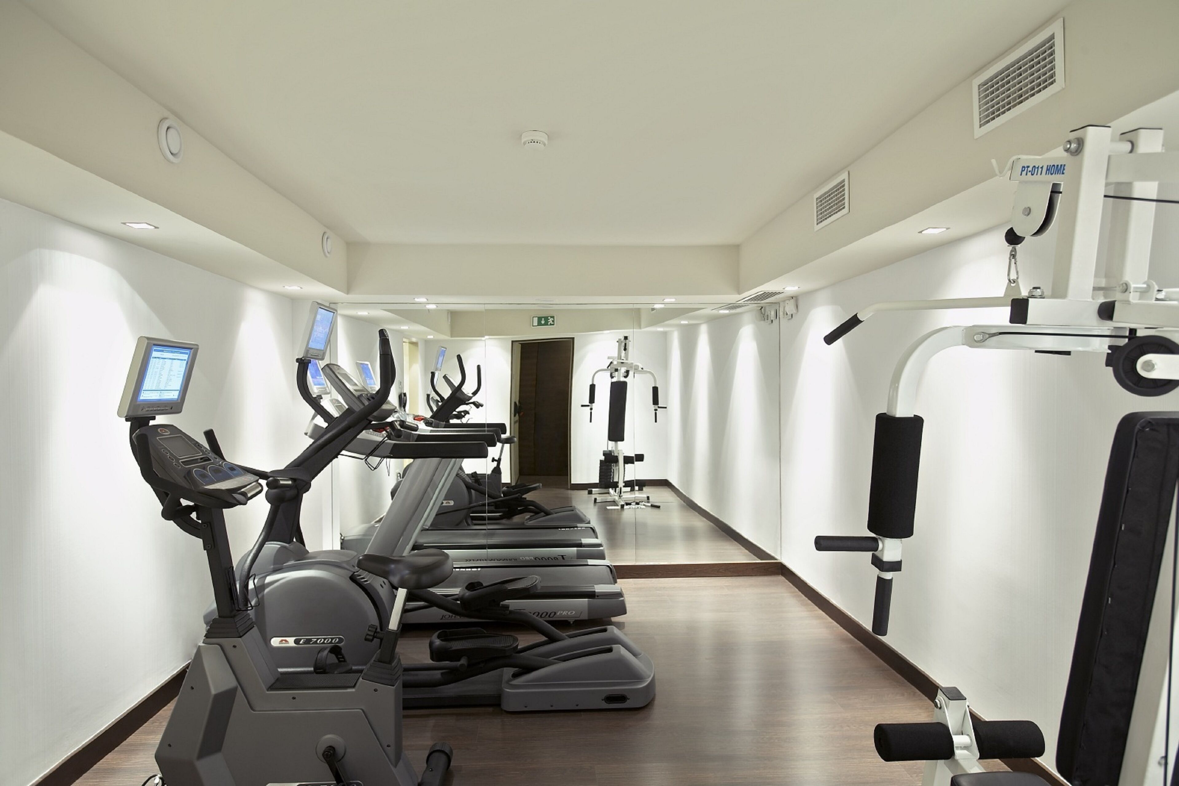 Een sportschool met loopbanden, elliptische trainers en krachtapparaten.