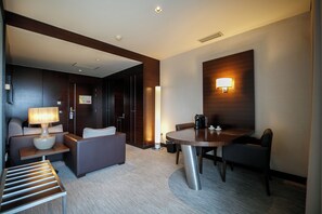 A modern hotel room with a sofa, a table, and a lamp. - BessaHotel Boavista (Porto)