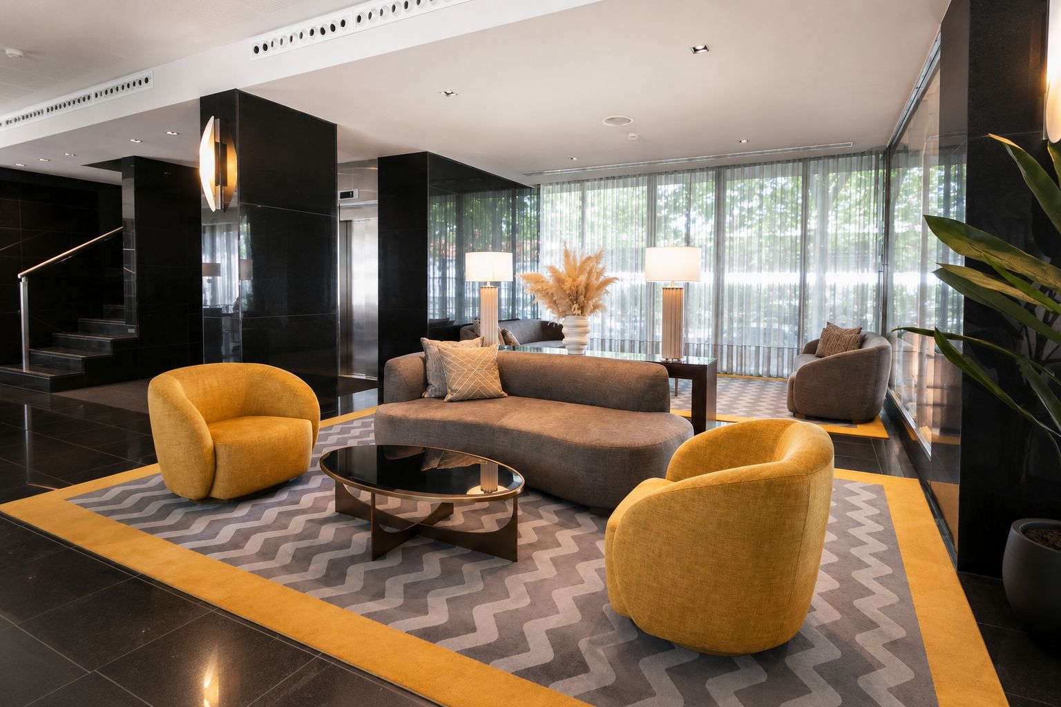 A modern lobby with a sofa set, two armchairs, a coffee table, and a staircase.