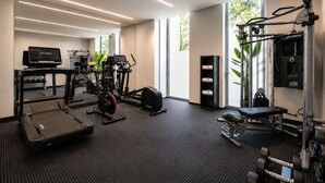 A modern gym with treadmills, elliptical machines, and weightlifting equipment. - BessaHotel Boavista (Porto)