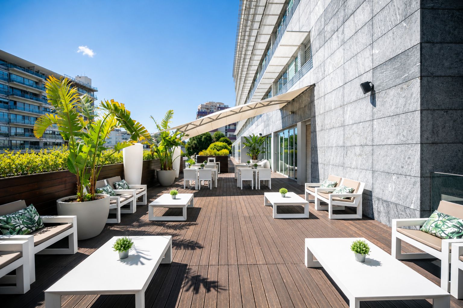 Una terraza en la azotea con mobiliario exterior, plantas en macetas y vistas panorámicas de la ciudad.