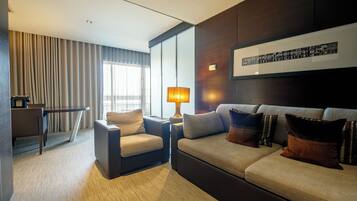 Suite Deluxe with Jacuzzi | Wohnbereich | 43-Zoll-Smart-TV mit Kabelempfang, Fernseher, Bücher