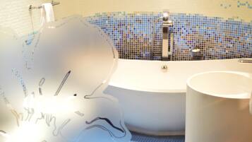 Un baño con una bañera blanca, un lavamanos blanco y una pared con mosaicos de azulejos.