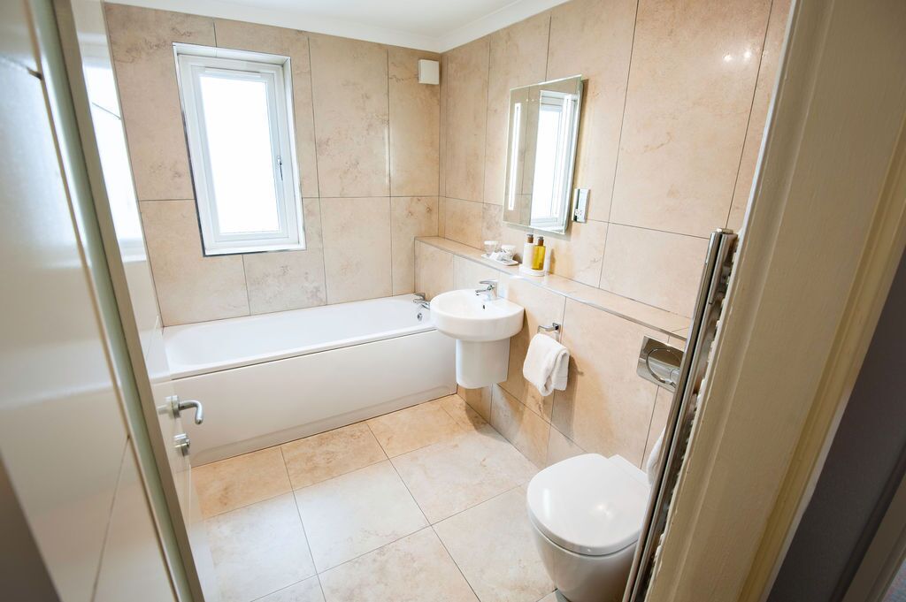 A modern bathroom with a bathtub, sink, and toilet.