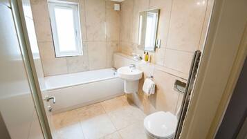 A modern bathroom with a bathtub, sink, and toilet.