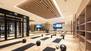 A modern fitness center with wooden flooring, black exercise mats, and exercise balls. - Seamill Hydro Hotel & Resort (West Kilbride)