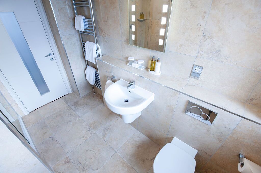 Un baño moderno con lavamanos, inodoro y toallero.